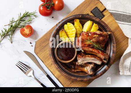 Gegrilltes Kalbsbrust-Fleisch vom Grill und Pommes Frites-Kartoffeln mit Sauce auf einer Marmorplatte. Draufsicht, flach liegend. Stockfoto