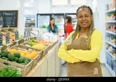 Selbstbewusster afroamerikanischer Verkäufer im Lebensmittelgeschäft Stockfoto