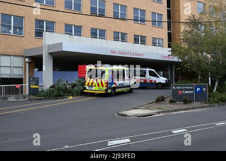 Haupteingang zum Cabrini Krankenhaus, mit einem Krankenwagen und einem Patiententransportfahrzeug, das in der Nähe des Eingangs der Notaufnahme geparkt ist Stockfoto