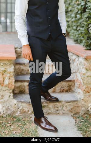 Ein Mann steht in einem festlichen Kostüm auf der Treppe. Vorbereitung auf die Feier Stockfoto