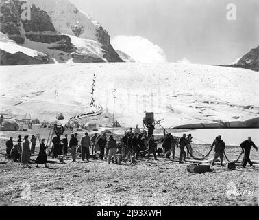 JAMES STEWART (auf dem Pferd) und Movie Crew am Drehort für DAS FERNE LAND: Ehrliche Dreharbeiten auf dem Athabasca-Gletscher im Jasper National Park, Kanada 1954 Regisseur ANTHONY MANN Geschichte / Drehbuch Borden Chase Kinematographie William H. Daniels Universal International Picches Stockfoto