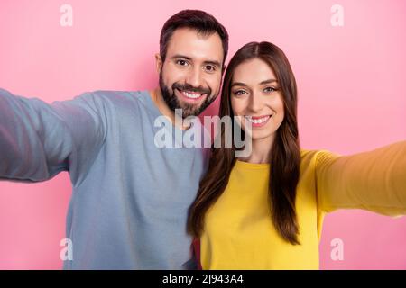 Portrait von zwei positiven netten Partnern machen Selfie-Aufnahme Video toothy Lächeln isoliert auf rosa Hintergrund Stockfoto