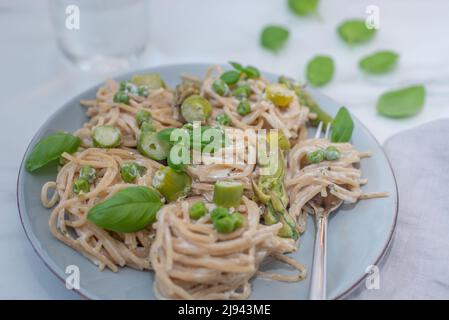 italienische Spaghetti mit grünem Spargel auf einem Tisch Stockfoto