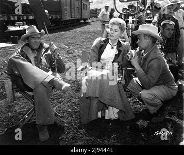 JAMES STEWART ALAINE STEWART und Regisseur JAMES NEILSON mit Movie Crew am Drehort offen in den Colorado Rockies während der Dreharbeiten zur NIGHT PASSAGE 1957 Story Norman A. Fox Drehbuch Borden Chase Musik Dimitri Tiomkin Kameramann William H. Daniels Kostümdesign Bill Thomas Universal International Pictures Stockfoto