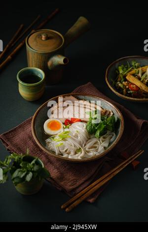 Asiatische Nudelsuppe auf dem Tisch, Ramen mit Schweinefleisch, Gemüse und Ei in einer Schüssel. Speicherplatz kopieren Stockfoto