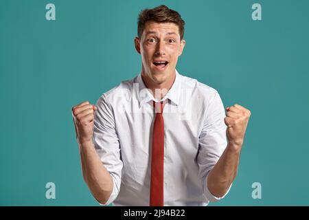 Porträt eines jungen Brunet-Mannes, der vor blauem Hintergrund in einem Studio posiert. Stockfoto