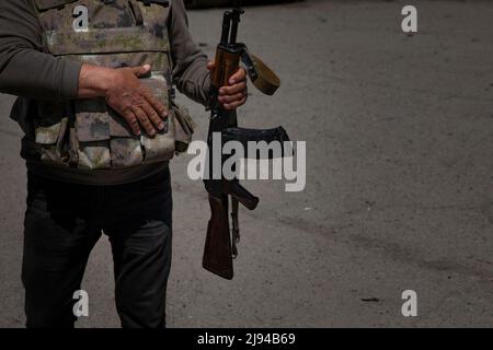 Barwinkowe, Oblast Charkiw, Ukraine. 20.. Mai 2022. Der Bürgermeister von Barvinkove, Alexander Balo, ergreift sein Gewehr, während er mit einem mechanisierten Brigadeoffizier aus dem Jahr 93. spricht, der nicht abgebildet ist, während Balo am 20. Mai 2022 auf den Straßen von Barvinkove, Ukraine, ging. „Dies ist nicht nur ein Krieg, itÃs ein Völkermord an unserer ukrainischen Nation“, sagte er. (Bild: © Daniel Carde/ZUMA Press Wire) Stockfoto