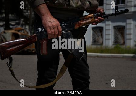 Barwinkowe, Oblast Charkiw, Ukraine. 20.. Mai 2022. Der Bürgermeister von Barvinkove, Alexander Balo, ergreift sein Gewehr, während er mit einem mechanisierten Brigadeoffizier aus dem Jahr 93. spricht, der nicht abgebildet ist, während Balo am 20. Mai 2022 auf den Straßen von Barvinkove, Ukraine, ging. „Dies ist nicht nur ein Krieg, itÃs ein Völkermord an unserer ukrainischen Nation“, sagte er. (Bild: © Daniel Carde/ZUMA Press Wire) Stockfoto