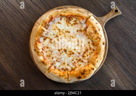 Frische Pizza mit vier Käsesorten in Scheiben auf einem Holztisch Stockfoto