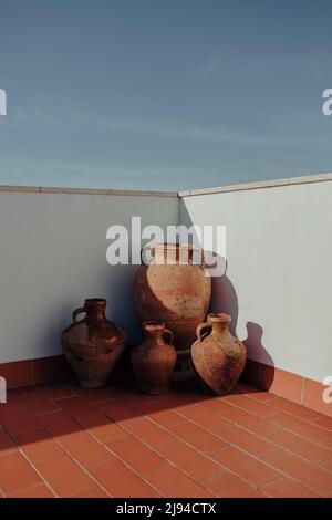 Alte zerbrochene große Schlammbehälter auf dem Boden draußen in einer Dachecke mit rauem Licht Stockfoto