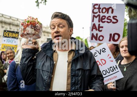 London, Großbritannien. 20 Mai 2022. Fernsehkoch Jamie Oliver vor der Downing Street bei einem Protest in Eton Mess. Um die Gesundheit von Kindern zu schützen, wollen die Demonstranten, dass die Regierung ihre Entscheidung, ein Jahr lang ein Verbot von „Buy-one-get-one-free“-Geschäften für ungesunde Lebensmittel und ein Verbot von TV-Junk-Food-Anzeigen vor einer Wendeschneidbildung im Jahr 9pm zu verschieben, rückgängig macht. Die Regierung sagt, dass die Verschiebung eine Überprüfung der Auswirkungen auf die Haushalte angesichts der Lebenshaltungskrise ermöglichen wird. Eton Mess ist ein Dessert, das darauf verweist, wo Boris Johnson, Premierminister, zur Schule ging. Kredit: Stephen Chung / Alamy Live Nachrichten Stockfoto