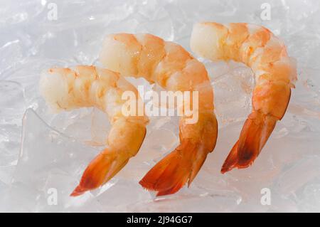 Nahaufnahme einer Auswahl roher Garnelen auf Eis, die zum Verkauf angeboten werden. Stockfoto