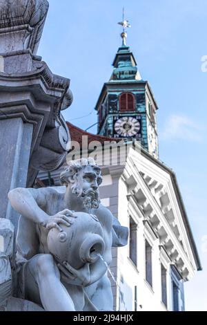 Ljubljana, Slowenien - 07.15.2021: Marmorfigur des Brunnens mit dem Stadthaus-Backgrownd in Ljubljana Stockfoto