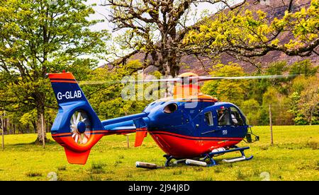 Blau und rot G-GLAB - Airbus Helicopter H135 schwebt in Vorbereitung auf den Start, Applecross Peninsula, Bealach na Ba, North Coast 500, Schottland Stockfoto