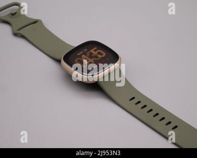 Mai 2022, UK: Fitbit Versa 3 Fitness Tracker Clock Face Olive Green Band. Leuchtete Anzeige eingeschaltet. Stockfoto