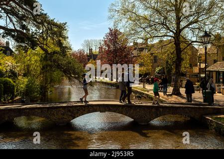 Sightseeing-Touristen in Bourton-on-the-Water, berühmt für seine niedrigen Steinbrücken über den Fluss Windrush, Cotswolds, Gloucestershire, England, Großbritannien. Stockfoto