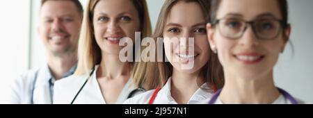 Gruppe von fröhlich Praktizierenden jungen Ärzten in Uniform Stockfoto