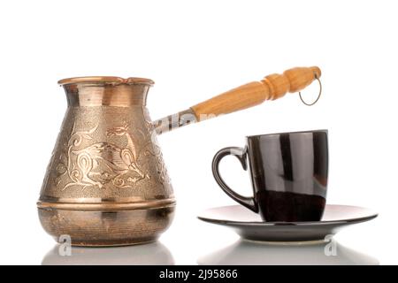 Eine türkische Cezve-Kaffeekannen aus Kupfer mit schwarzer Keramikschale, Nahaufnahme, isoliert auf weißem Hintergrund. Stockfoto