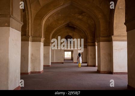 Eine einjährige Frau, die durch die Gänge von Akbars Grab in Sikandara, Agra, Indien, läuft Stockfoto