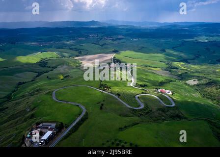 Kurvenreiche Straße zwischen den Hügeln der Toskana. Luftaufnahme Stockfoto