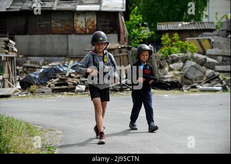 Stojanka, Ukraine. 19.. Mai 2022. Ukrainische Kinder spielen im Dorf Stojanka, Region Kiew, auf Patrouillen gegen die territoriale Verteidigung. (Foto: Sergei Chuzavkov/SOPA Images/Sipa USA) Quelle: SIPA USA/Alamy Live News Stockfoto