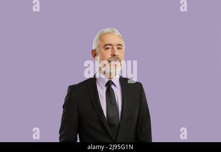 Porträt eines ernsthaften und selbstbewussten Geschäftsmannes isoliert auf pastellviolettem Hintergrund. Stockfoto