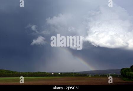 Langewiesen, Deutschland. 20.. Mai 2022. Vor dunklen Wolken bildet sich ein Regenbogen. Der Deutsche Wetterdienst hat vor starken Gewittern und einem großen Risiko von schweren Stürmen mit orkanlastigen Winden und Starkregen gewarnt. Quelle: Martin Schutt/dpa/Alamy Live News Stockfoto