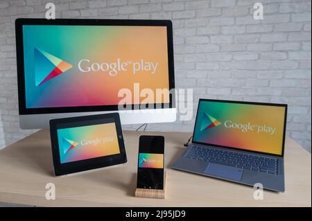 Google Play-Logo auf den Bildschirmen eines Telefons, digitalen Tablets, Laptops und Computers. Ein Geschäft mit Anwendungen, Büchern, Musik, Spielen und Filmen für alle Stockfoto