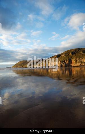 Brean Down spiegelt sich im nassen Sand von Brean Beach. Somerset, Großbritannien. Stockfoto