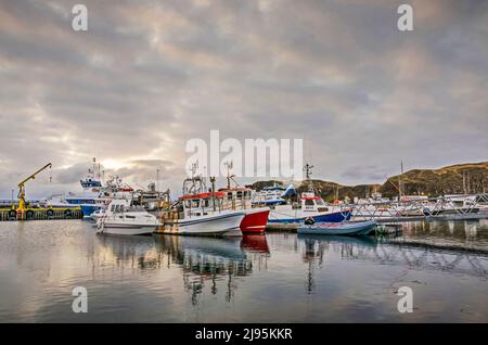 Stykkishólmur, Island, 4. Mai 2022: Ein dramatischer Himmel kurz vor Sonnenuntergang, der sich im Hafen der Stadt widerspiegelt Stockfoto