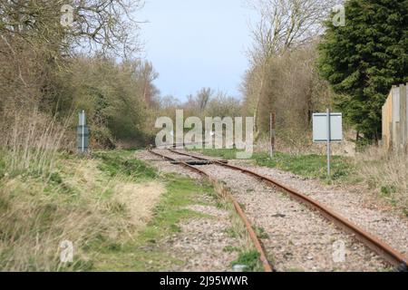 Eine gebogene eingleisige Eisenbahnzweigstrecke im Vereinigten Königreich mit gegliedertem Gleis Stockfoto