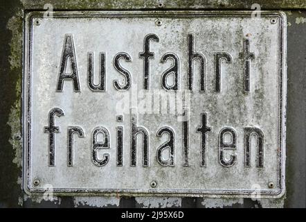 Nahaufnahme eines verwitterten weißen Schildes mit der Aufschrift „Abfahrt frei“, was soviel bedeutet wie „Ausfahrt frei halten“ Stockfoto