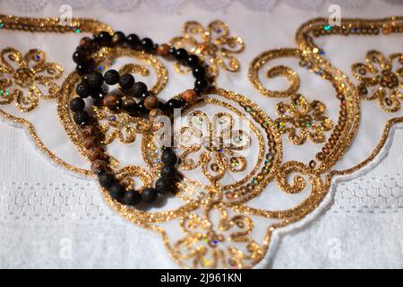 Zwei Rosenkränze und traditionelle goldfarbene Stickerei Stockfoto