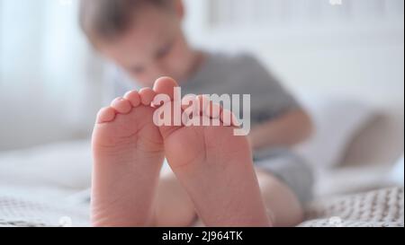 Nahaufnahme der Beine der Kinder mit den Füßen nach vorne Stockfoto