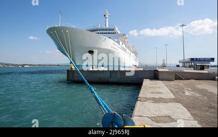 Großes Luxuskreuzfahrtschiff auf Meerwasser und wolkiger Himmelshintergrund dockten am Hafen an Stockfoto