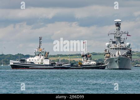 Die Königliche Navy Fregatte HMS Kent (F78) wird nach einem Familientag auf See am 20.. Mai 2022 von Schleppern auf dem Marinestützpunkt in Portsmouth Harbour, Großbritannien, unterstützt. Stockfoto
