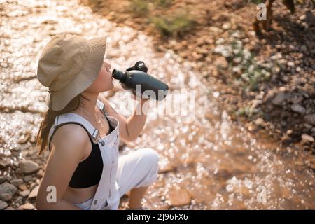 Weibliche Touristen Trinkwasser.Frau, die während der Wanderung mit einer Wasserflasche ruht Stockfoto