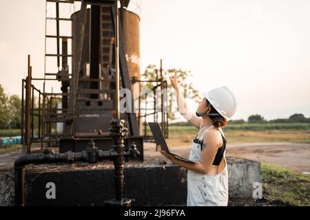 Petrochemische Technik asiatische Frau mit Schutzhelm stehen in der Ölraffinerie Struktur petrochemische Industrie. Stockfoto