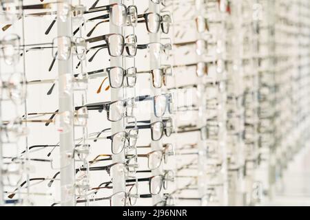 Stellen Sie sich mit einer Brille in den Laden der Optik. Vitrine mit Brillen im modernen Brillenladen Stockfoto