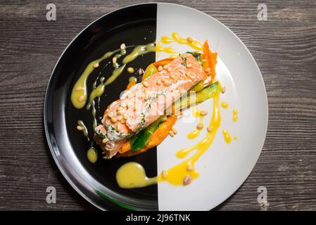 Lachssteak auf einem Teller mit thailändischem Gemüse und süßer und saurer Mangosauce Stockfoto