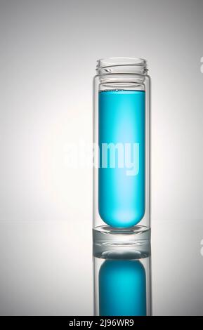Transparente Glasflasche mit schwarzem Deckel. Mit blauer Flüssigkeit, auf weißem Hintergrund. Stockfoto