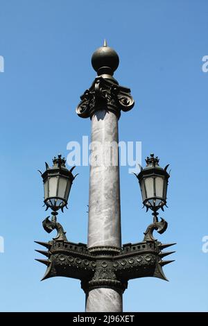 Lampenpfahl aus altem Marmor und Bronze mit Lampenhaltern in Form eines Schiffshülls (Symbol von Paris) vor dem Pariser Opernhaus. Stockfoto