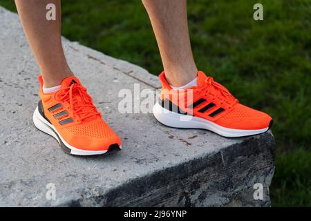 Tjumen, Russland-03. Mai 2022: Adidas Laufschuhe, orange Korallenfarbe, eq21 Lauf. Nahaufnahme des Logos Stockfoto