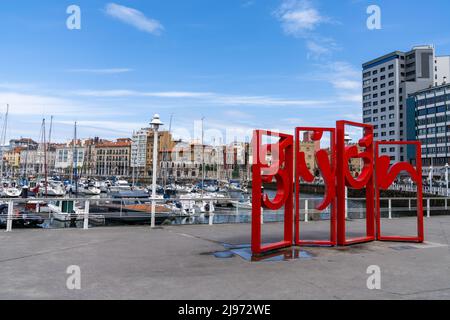 Gijon, Spanien - 24. April 2022: Blick auf den Sporthafen und den Hafen von Gijon mit dem Stadtnamen in roten Buchstaben Stockfoto