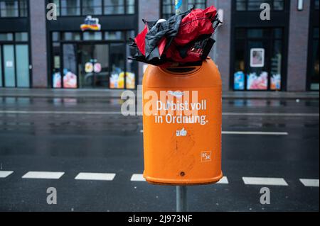 20.02.2022, Berlin, Deutschland, Europa - Ein zerbrochener Regenschirm, der in einen überfließenden Mülleimer der BSR mit der Aufschrift 'Du bist voll in Ordnung' gequetscht wurde. Stockfoto