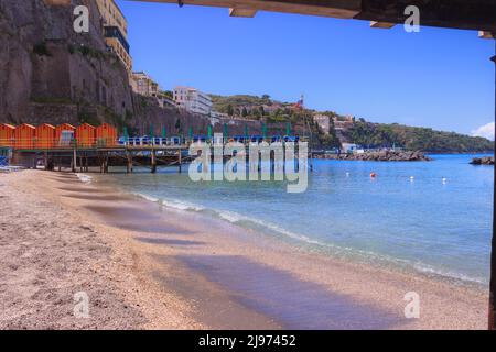 Sommer: Sorrento Strand in Italien. Blick auf die mit Strandhütten und Sonnenschirmen gesäumten Stege am Meer. Stockfoto