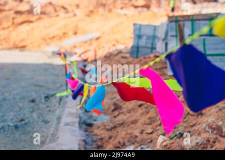 Fahnen rosa rot blau Zaun Open Air gefärbt. Baustelle für Industriegelände. Gebäude Zement gepresste Materialien Betonblock Ziegel. Fertig Stockfoto