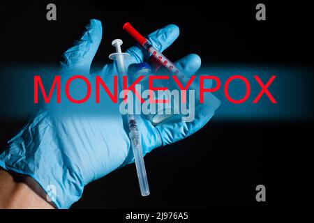 Monkeypox-Virus (MPXV)-Konzept: Wissenschaftler, der mit dem Monkeypox-Virus infiziertes Blut in einem Reagenzglas auf weißem Hintergrund hält. Stockfoto