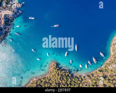 Luftaufnahmen von Drohnen von Tagesbooten und privaten Yachten, die in der Cennet Bay im Dorf Selimiye im Bezirk Marmaris der Stadt Muğla, TU, vor Anker liegen Stockfoto