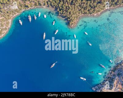 Luftaufnahmen von Drohnen von Tagesbooten und privaten Yachten, die in der Cennet Bay im Dorf Selimiye im Bezirk Marmaris der Stadt Muğla, TU, vor Anker liegen Stockfoto